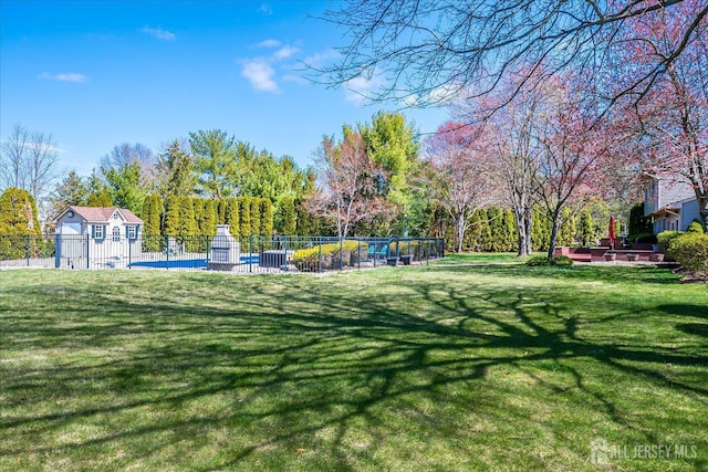 view of property's community with fence and a lawn