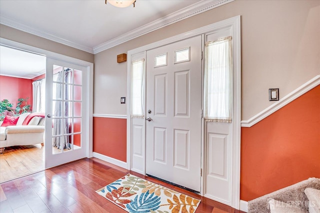 entryway with ornamental molding, baseboards, and wood finished floors