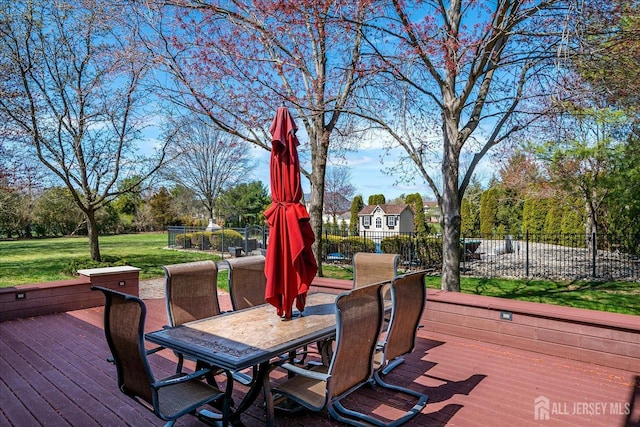 deck with a yard, outdoor dining space, and fence