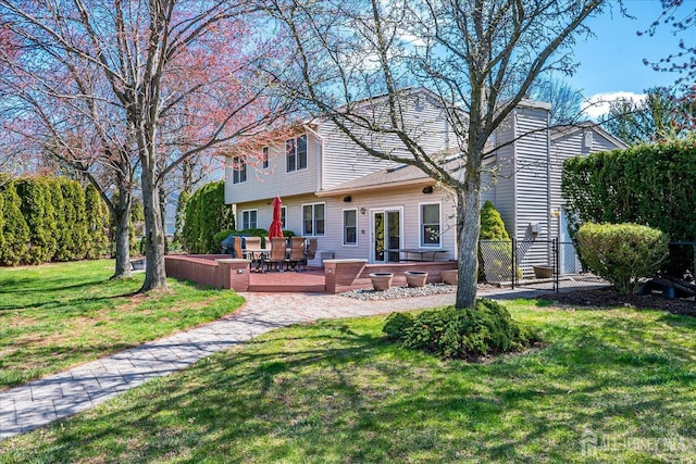 back of house featuring a wooden deck and a lawn