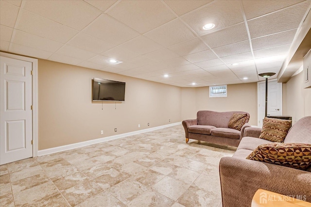 living room with baseboards and a paneled ceiling