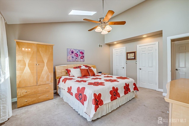 bedroom featuring visible vents, ceiling fan, a skylight, high vaulted ceiling, and carpet flooring