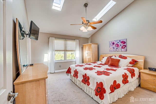 bedroom with baseboards, a ceiling fan, carpet floors, a skylight, and high vaulted ceiling