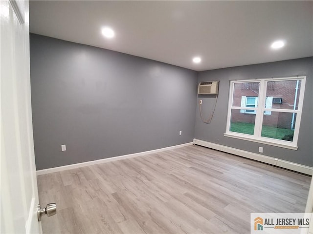 unfurnished room with a baseboard heating unit, wood finished floors, an AC wall unit, and recessed lighting