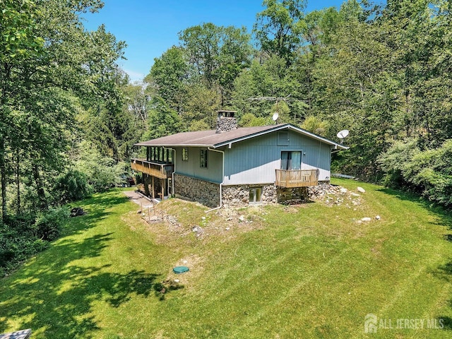 34 Stony Brook Rd, Blairstown, NJ 07825 - view of home's exterior featuring stone siding, a lawn, a chimney, and a wooded view