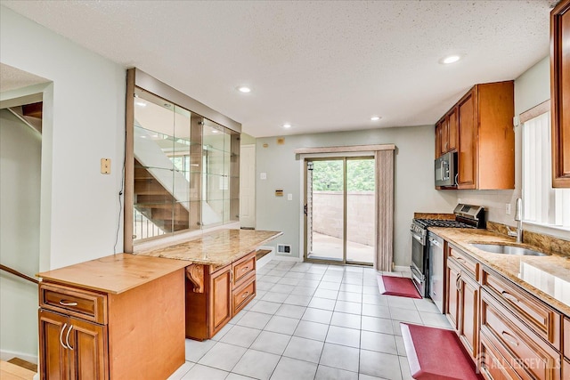 68 Kelly Dr, Edison, NJ 08820 - kitchen with stainless steel appliances, brown cabinets, recessed lighting, light stone counters, and a textured ceiling