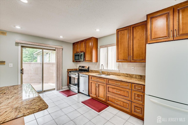68 Kelly Dr, Edison, NJ 08820 - kitchen featuring appliances with stainless steel finishes, brown cabinetry, recessed lighting, a textured ceiling, and light stone counters