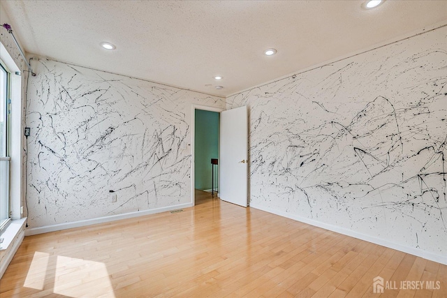 68 Kelly Dr, Edison, NJ 08820 - empty room with recessed lighting, stone wall, wood finished floors, a textured ceiling, and an accent wall