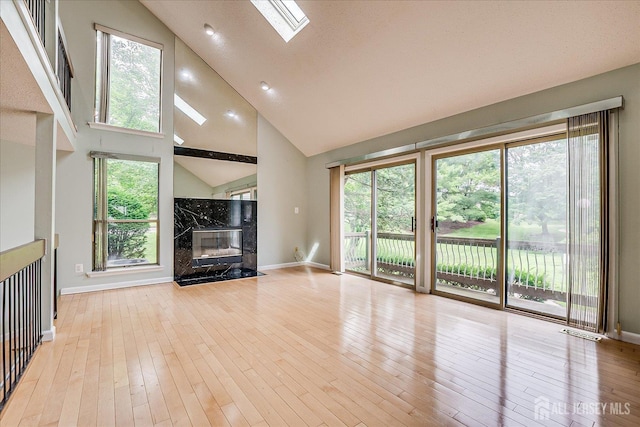68 Kelly Dr, Edison, NJ 08820 - unfurnished living room featuring a fireplace, a skylight, high vaulted ceiling, and wood-type flooring