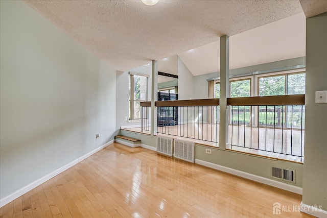 68 Kelly Dr, Edison, NJ 08820 - empty room with wood-type flooring, a textured ceiling, and lofted ceiling