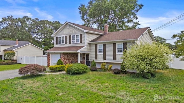 31 Brunswick Dr, Howell, NJ 07731 - split level home featuring a chimney, an attached garage, asphalt driveway, and roof with shingles