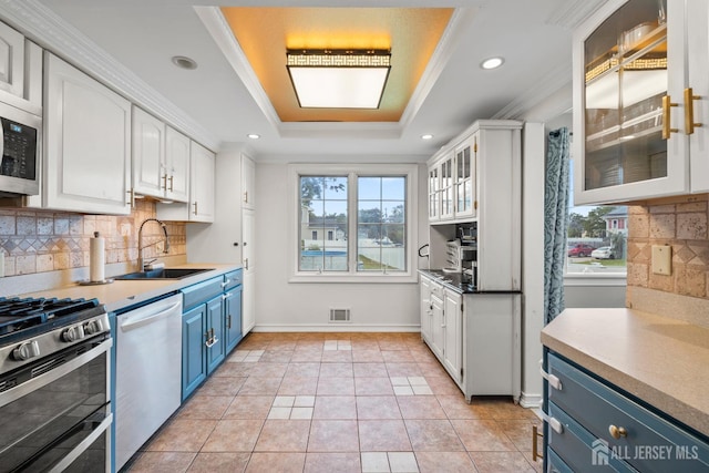 31 Brunswick Dr, Howell, NJ 07731 - kitchen with blue cabinetry, appliances with stainless steel finishes, white cabinets, a raised ceiling, and ornamental molding