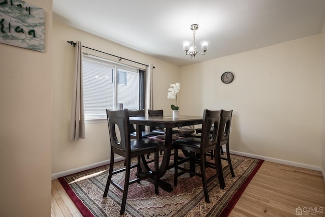 dining area with a notable chandelier and hardwood / wood-style floors