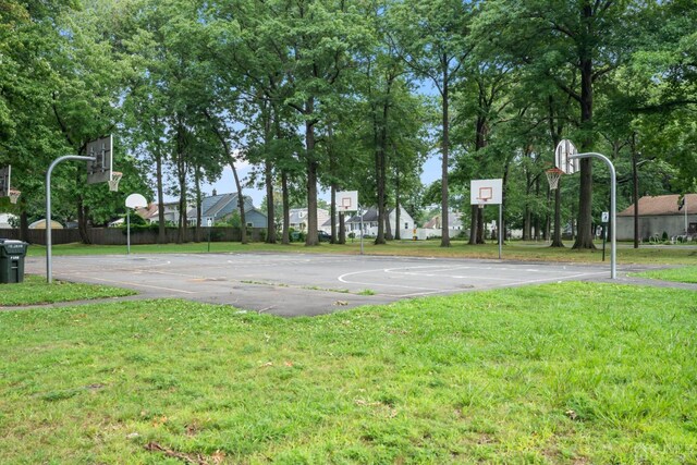 view of sport court featuring a lawn