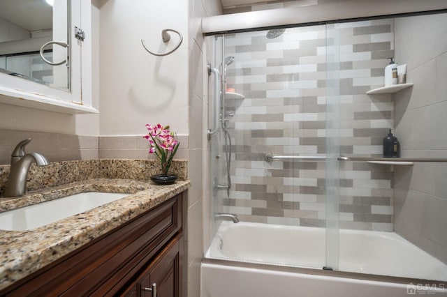 bathroom with vanity and bath / shower combo with glass door