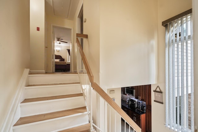 stairs featuring ceiling fan