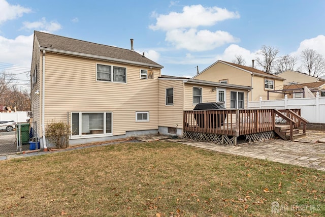 rear view of property featuring a yard and a deck