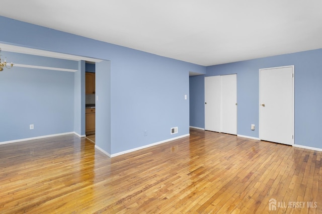 1724 Country Mill Dr, East Windsor, NJ 08512 - unfurnished bedroom with light wood-type flooring, multiple closets, a chandelier, and baseboards