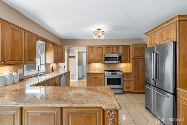 8 Garvey Dr, Monroe, NJ 08831 - kitchen featuring appliances with stainless steel finishes, light stone countertops, a peninsula, and decorative backsplash