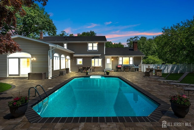 8 Garvey Dr, Monroe, NJ 08831 - back of property at dusk featuring a patio and a chimney