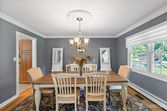 8 Garvey Dr, Monroe, NJ 08831 - dining area featuring wood finished floors, a chandelier, baseboard heating, and crown molding