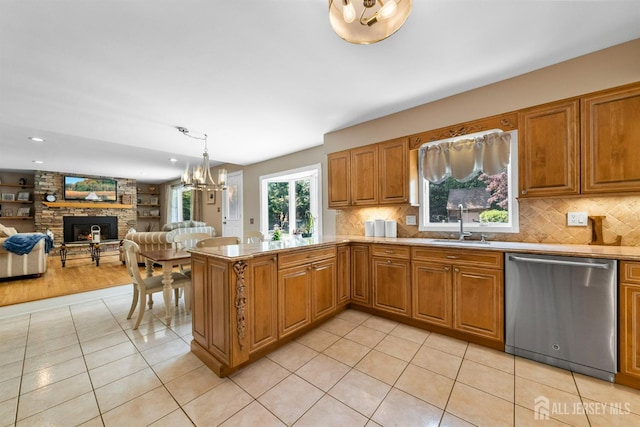 8 Garvey Dr, Monroe, NJ 08831 - kitchen featuring dishwasher, light tile patterned floors, a chandelier, a stone fireplace, and brown cabinets