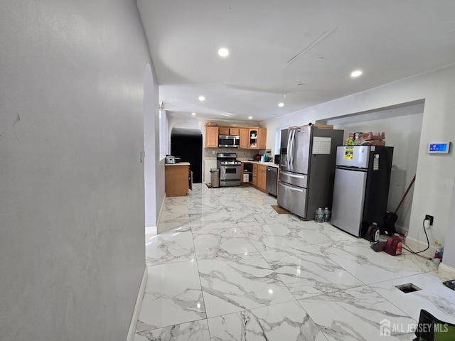 kitchen with recessed lighting, brown cabinets, stainless steel appliances, and marble finish floor