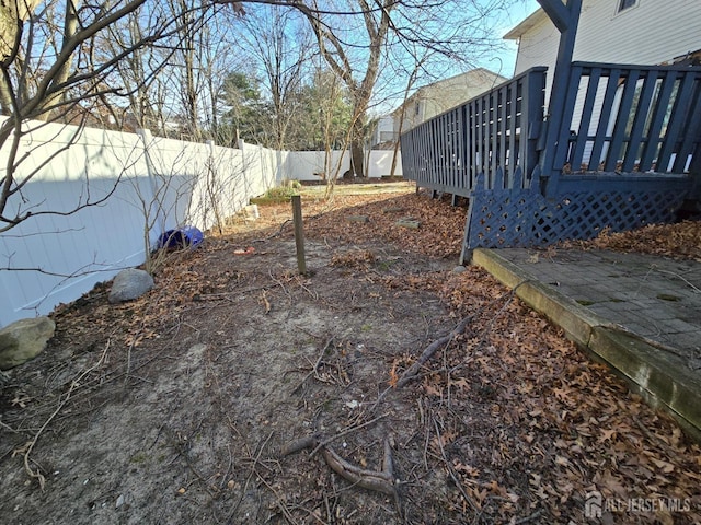 view of yard with a fenced backyard and a wooden deck