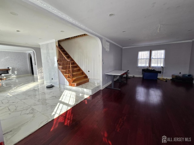 interior space featuring hardwood / wood-style flooring, stairway, arched walkways, and ornamental molding