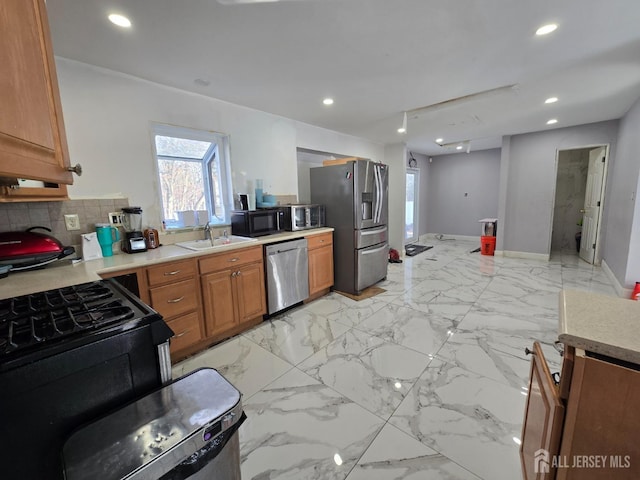 kitchen featuring recessed lighting, a sink, black appliances, light countertops, and tasteful backsplash