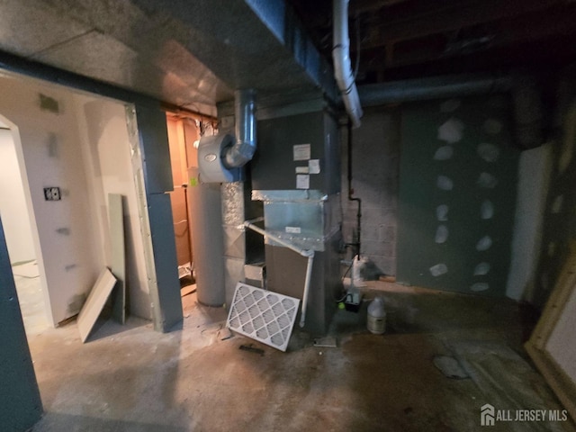 unfinished basement featuring heating unit and water heater