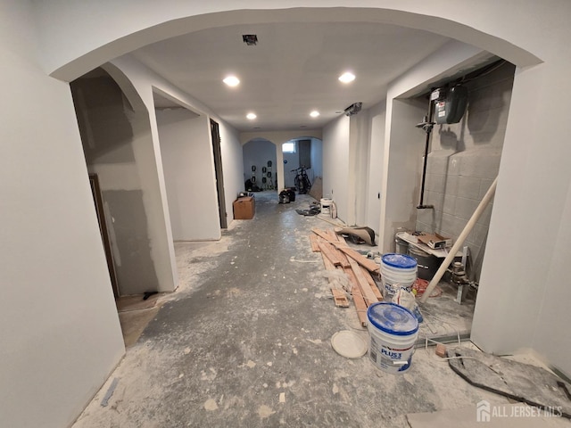 basement with arched walkways and recessed lighting