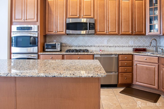 53 Mandrake Rd, Monroe, NJ 08831 - kitchen with stainless steel appliances, a sink, light tile patterned floors, light stone countertops, and backsplash