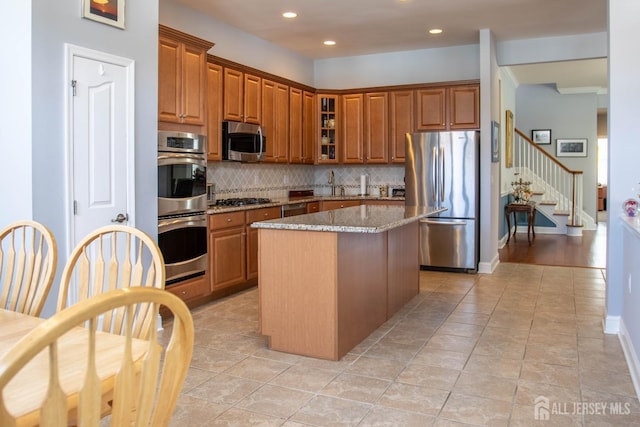 53 Mandrake Rd, Monroe, NJ 08831 - kitchen featuring stainless steel appliances, brown cabinets, light stone countertops, tasteful backsplash, and recessed lighting