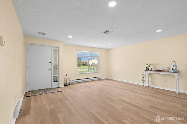 214 Branch Rd, Monroe, NJ 08831 - unfurnished living room featuring a baseboard heating unit, light wood-style flooring, a textured ceiling, recessed lighting, and baseboards