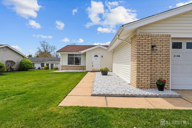 214 Branch Rd, Monroe, NJ 08831 - view of exterior entry featuring brick siding, a yard, and an attached garage