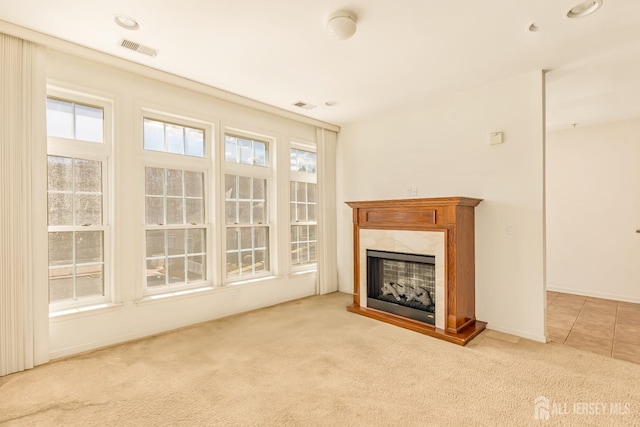 unfurnished living room with visible vents, baseboards, carpet flooring, and a fireplace