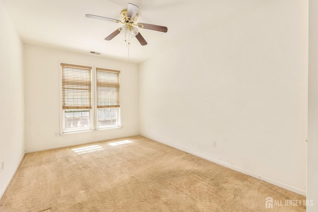 carpeted empty room featuring visible vents, baseboards, and ceiling fan