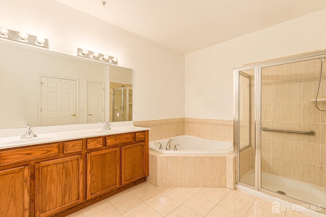 bathroom featuring a shower stall, tile patterned flooring, a garden tub, and a sink