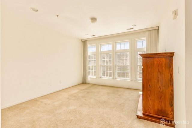 carpeted empty room with baseboards and visible vents