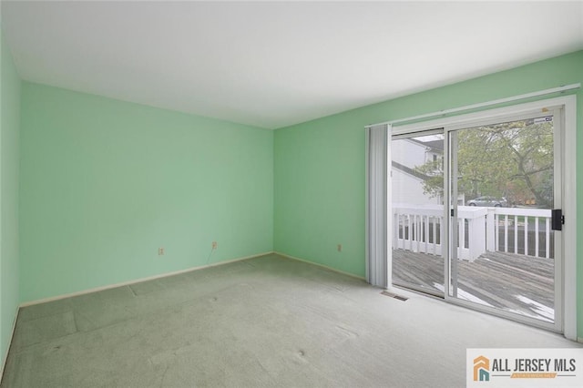 unfurnished room with carpet flooring, baseboards, and visible vents