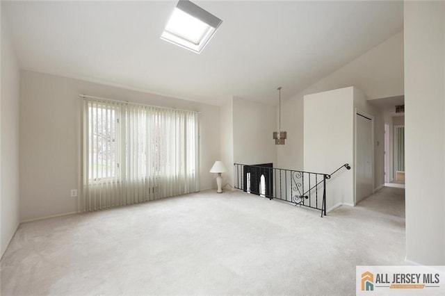 unfurnished room with vaulted ceiling, carpet, and baseboards