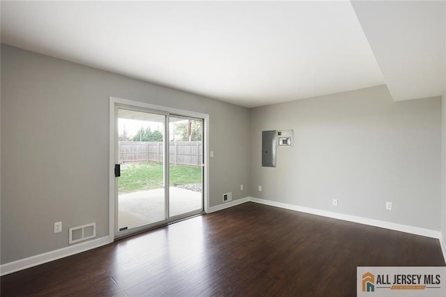 spare room with dark wood-type flooring, baseboards, and visible vents