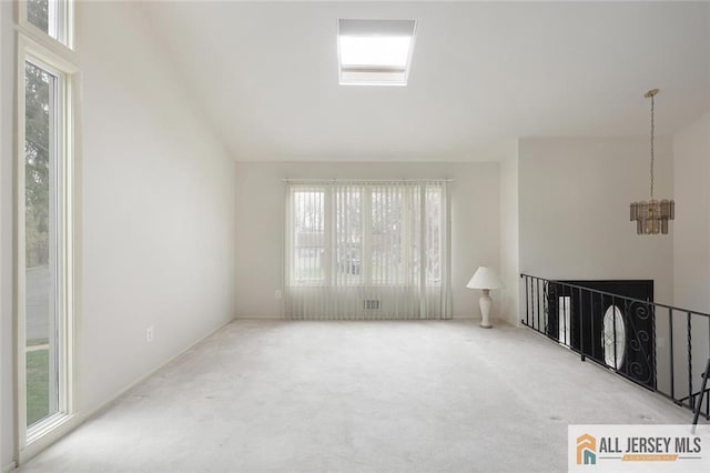 unfurnished living room featuring a notable chandelier and carpet