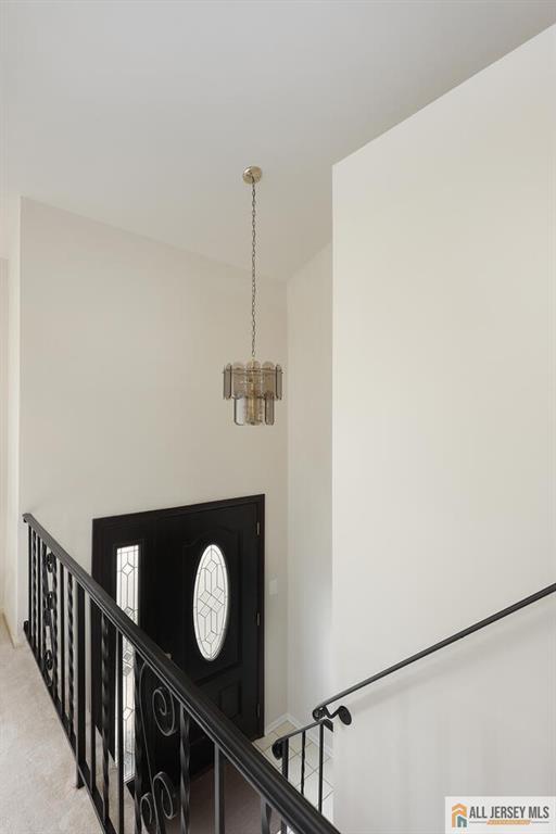 stairs featuring carpet flooring and a notable chandelier