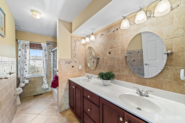 bathroom featuring a stall shower, a sink, tile walls, and double vanity