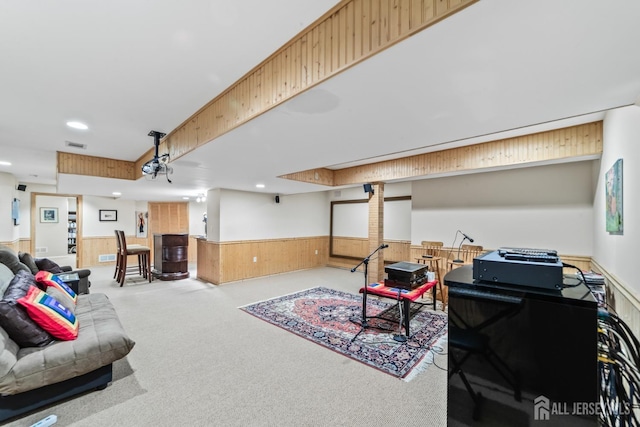 living area featuring a wainscoted wall, recessed lighting, visible vents, carpet flooring, and wooden walls