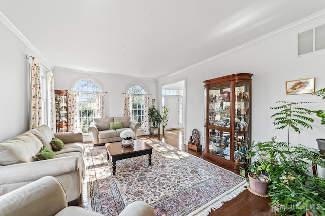 living area with visible vents, crown molding, and wood finished floors