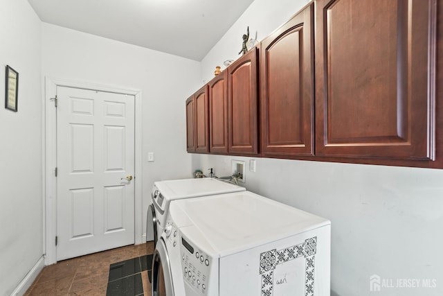 clothes washing area with baseboards, cabinet space, and washing machine and clothes dryer