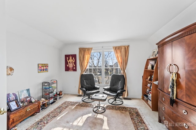 living area featuring light carpet, baseboards, and vaulted ceiling